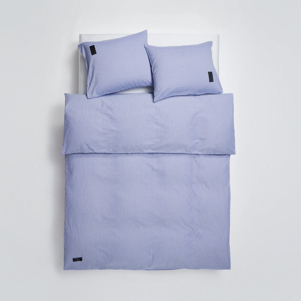 Magniberg Wall Street Duvet Cover - Stripe Dark Blue Oxford, a tailored bedding set featuring a crisp Oxford cotton duvet cover and matching pillow shams in a classic dark blue and white vertical stripe pattern. This sophisticated design offers a clean, contemporary minimalist aesthetic, crafted from high-quality, smooth cotton for comfortable sleep. Ideal for elevating any modern bedroom, master suite, or guest room with its timeless appeal and refined finish.
