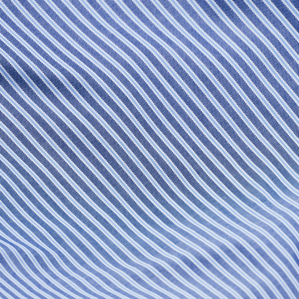 Magniberg Wall Street Pillow Case - Stripe Dark Blue, a sophisticated woven cotton pillowcase featuring crisp diagonal dark blue and light blue stripes with a fine white pin-dot texture on the darker bands. This classic blue and white striped bedding offers a refined, timeless aesthetic for any bedroom. Ideal for modern minimalist master bedrooms, elegant guest rooms, or creating a luxurious hotel-style bed linen look.