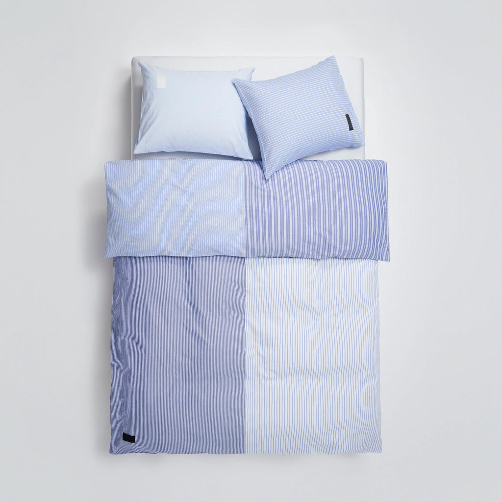 Magniberg Wall Street Pillow Case - Stripe Light Blue Oxford, a crisp Oxford cotton pillowcase featuring a classic light blue and white pinstripe pattern with a subtle woven texture. This tailored, modern pillow sham coordinates with the collection's contemporary blue striped bedding, offering a clean, minimalist aesthetic for any Scandinavian or classic bedroom.