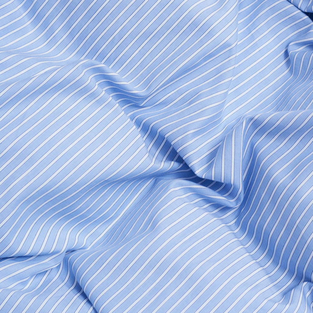 Magniberg Wall Street Pillow Case - Stripe Light Blue Oxford, a crisp light blue oxford cotton fabric featuring narrow white vertical stripes and a subtle woven texture. This classic striped pillowcase provides a timeless and minimalist aesthetic, perfect for modern bedroom decor and luxury bedding sets.