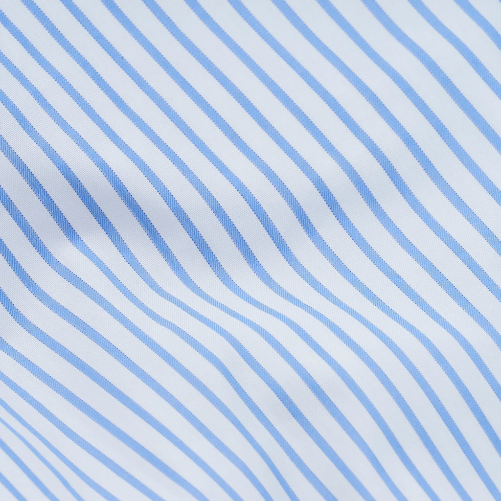 Magniberg Wall Street Pillow Case - Stripe White, a crisp cotton percale pillowcase featuring narrow light blue diagonal stripes on a clean white background, creating a classic and tailored aesthetic. This high-quality bedding is perfect for adding a refined touch to modern minimalist bedrooms or contemporary luxury interiors.