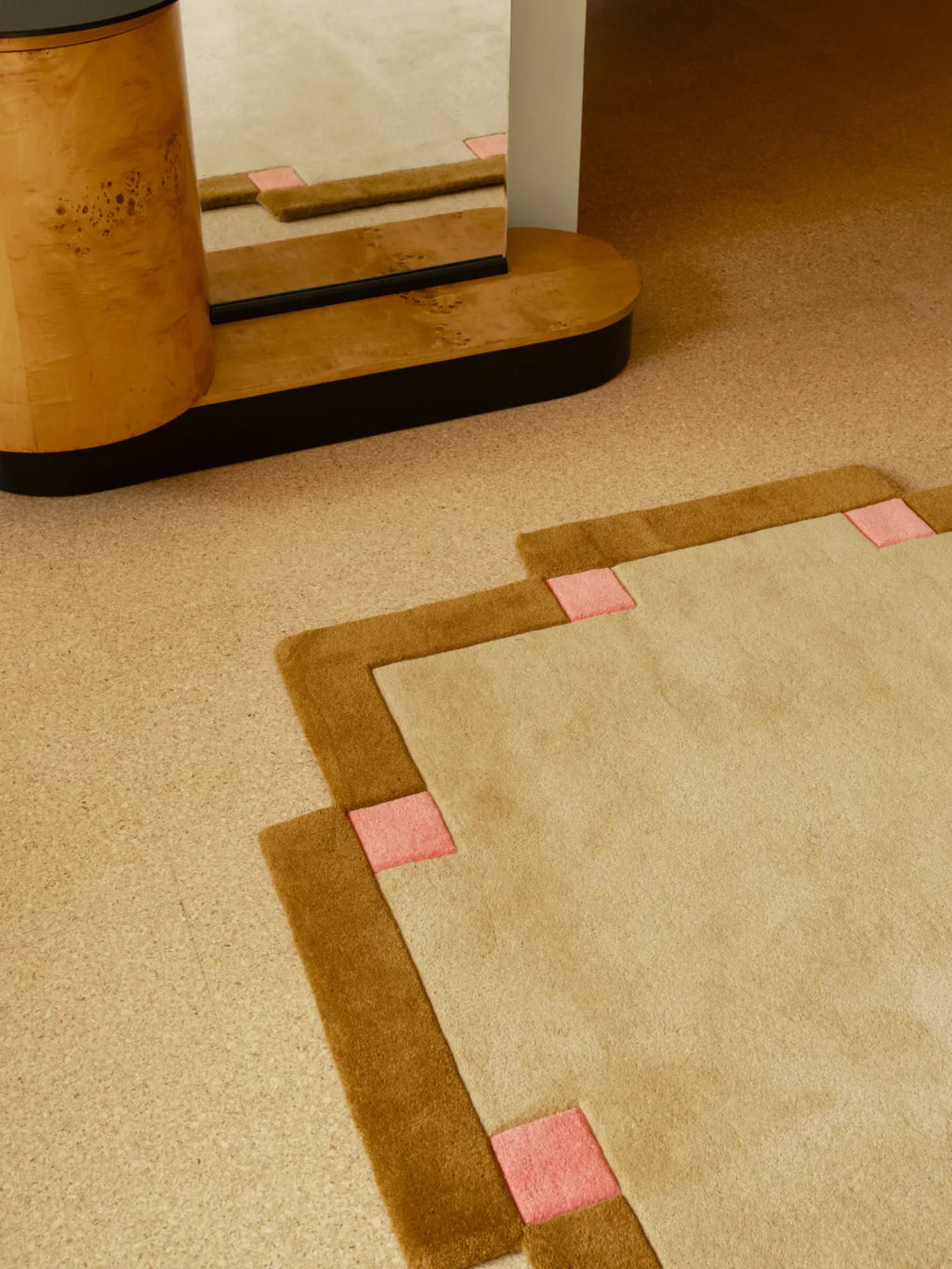 Layered Fregio Wool Rug, a modern beige and brown wool rug with playful pink square accents. Perfect for adding a unique, soft floor covering to any contemporary living space.