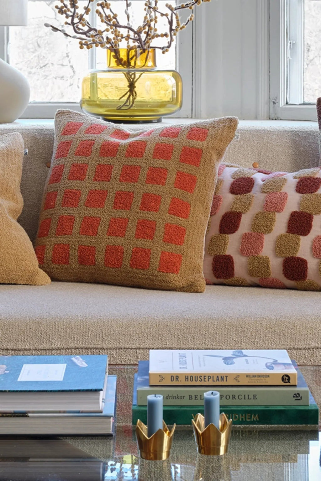Chhatwal & Jonsson Mohan Boucle Throw Pillow, a square decorative cushion featuring a warm tan base fabric with a striking grid pattern of raised, plush coral bouclé squares. This contemporary geometric throw pillow adds vibrant color and rich texture to any sofa or armchair. Perfect for global-inspired living rooms or cozy minimalist spaces seeking an accent cushion.