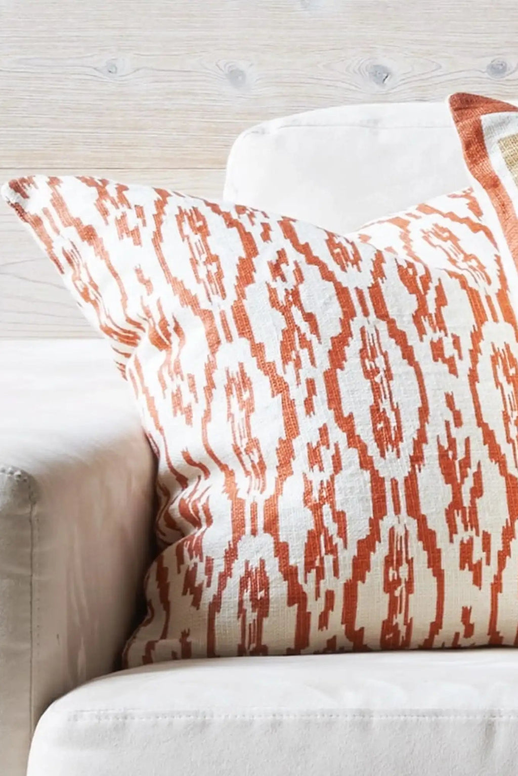 Chhatwal & Jonsson Deccan Linen Throw Pillow, a square decorative cushion featuring a vibrant terracotta and white ikat pattern on a textured, natural linen fabric. This handcrafted linen pillow showcases a global-inspired design with rich burnt orange hues, perfect for adding a boho chic or rustic Mediterranean accent to a living room sofa, bed, or armchair.
