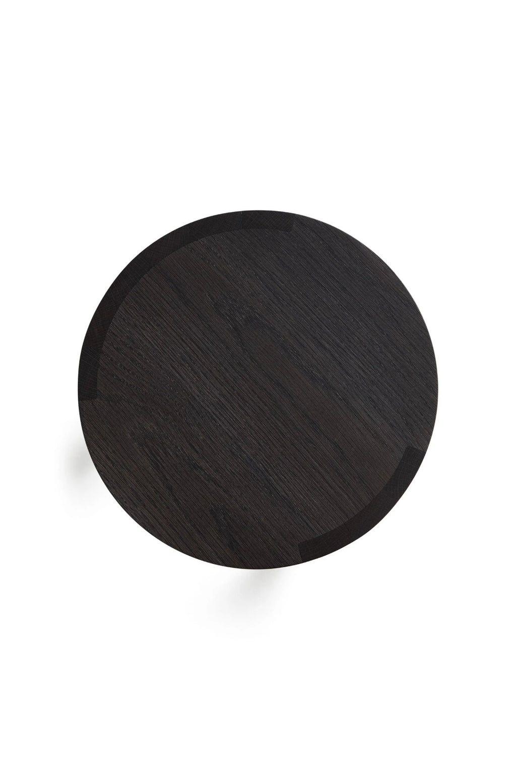 Made by Choice Airisto Side Table, a sleek modern minimalist round side table crafted from black stained solid oak with a visible wood grain and a subtly raised edge. This Scandinavian-inspired dark wood accent table features clean lines and thoughtful joinery details. Perfect as a contemporary bedside table or a chic living room side table for modern interiors.