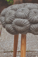 Handcrafted knit stool with soft fabric seat and wooden legs