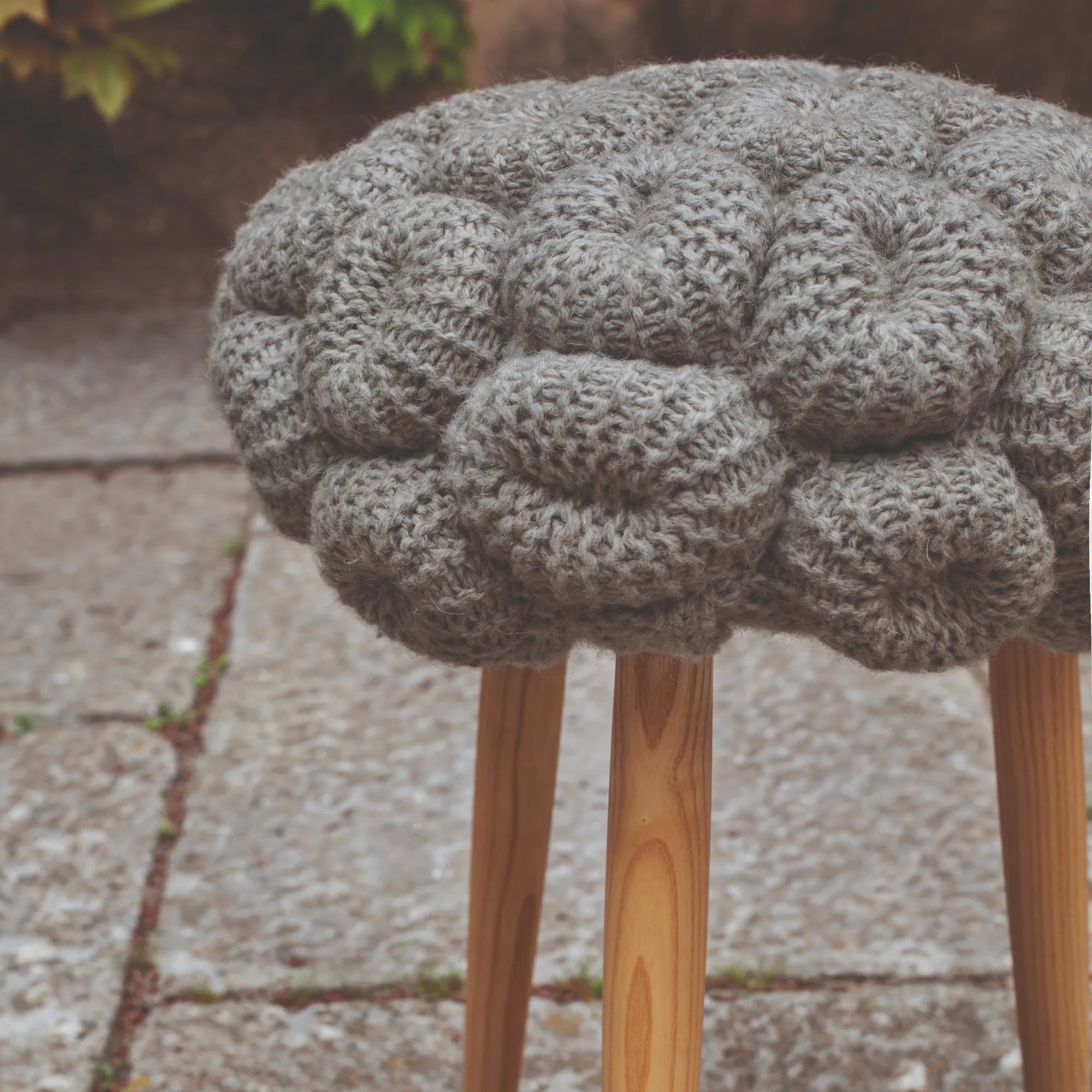 Handcrafted knit stool with soft fabric seat and wooden legs