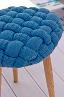 Cozy knitted stool in light blue perfect for adding warmth to any room