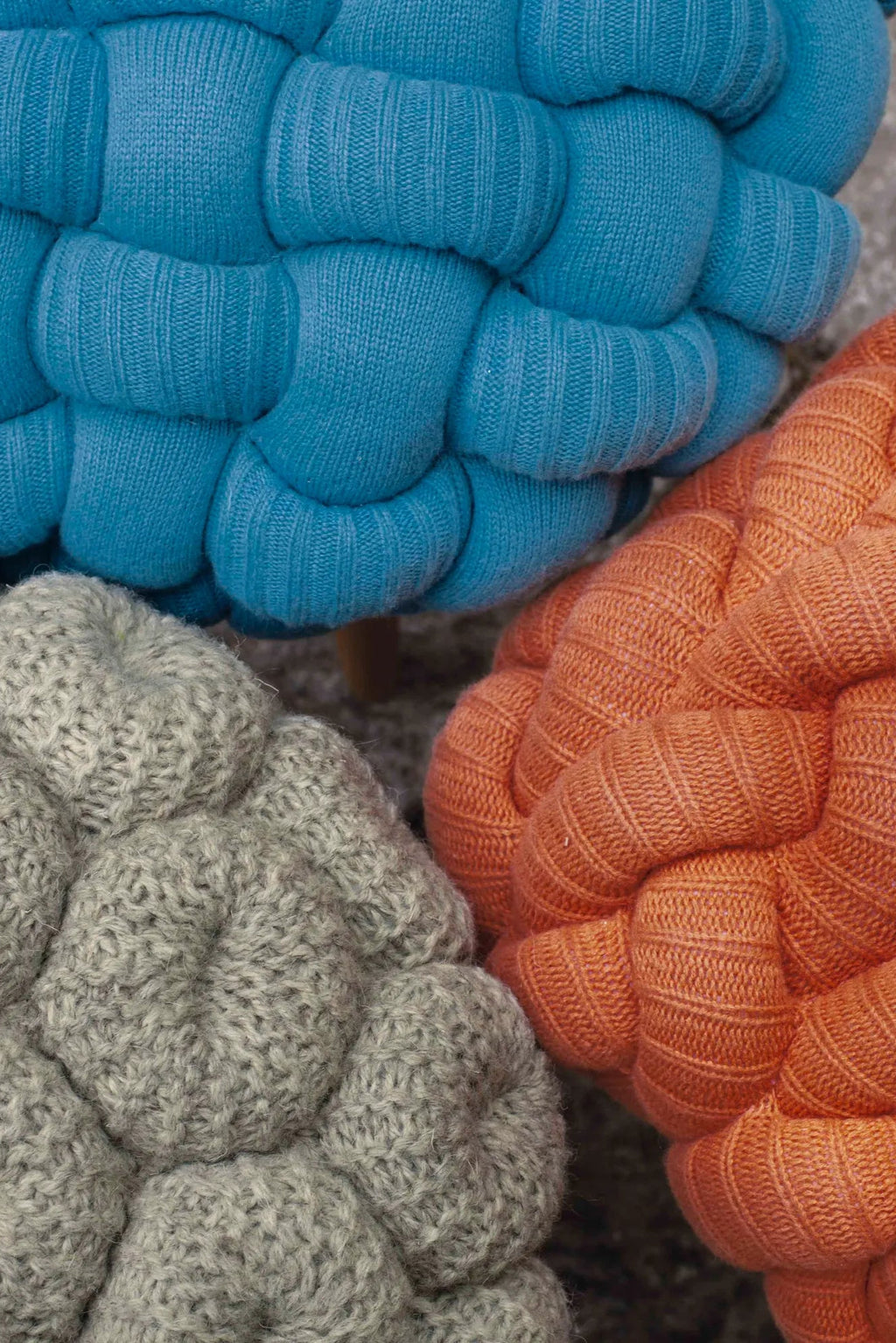 GAN Rugs Knitted Stool, a collection of plush, organic modern accent poufs featuring a distinctive braided knit texture.