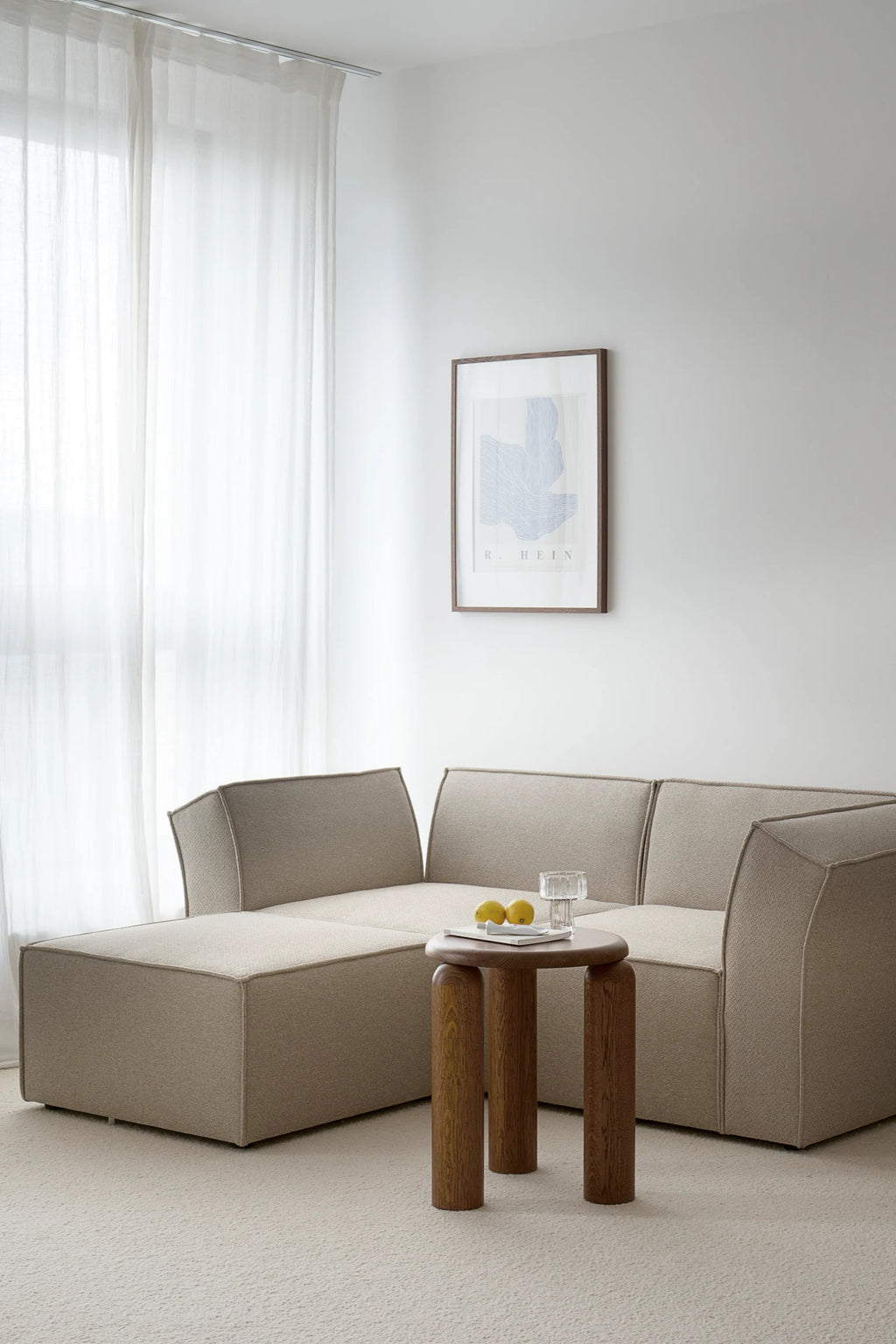 TAMO Neo Side Table in a lifestyle setting, showcasing its round dark brown oak top and three thick wooden legs. This elegant designer piece is perfect for modern living spaces.