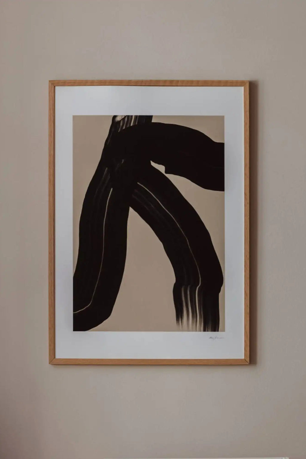 The Poster Club The Walk, a minimalist abstract art print featuring bold, organic black brushstrokes against a warm beige background with subtle texture. It is elegantly presented with a crisp white mat and framed in a light natural oak frame. Perfect as contemporary wall art for modern living rooms, Scandinavian bedrooms, or a stylish addition to any gallery wall.