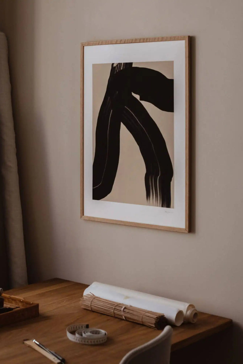 The Poster Club The Walk, a modern minimalist abstract art print featuring a bold black organic brushstroke with subtle texture against a soft beige background, framed with a crisp white mat and light natural oak frame. Perfect for contemporary gallery walls, Scandinavian living rooms, or a stylish home office accent.