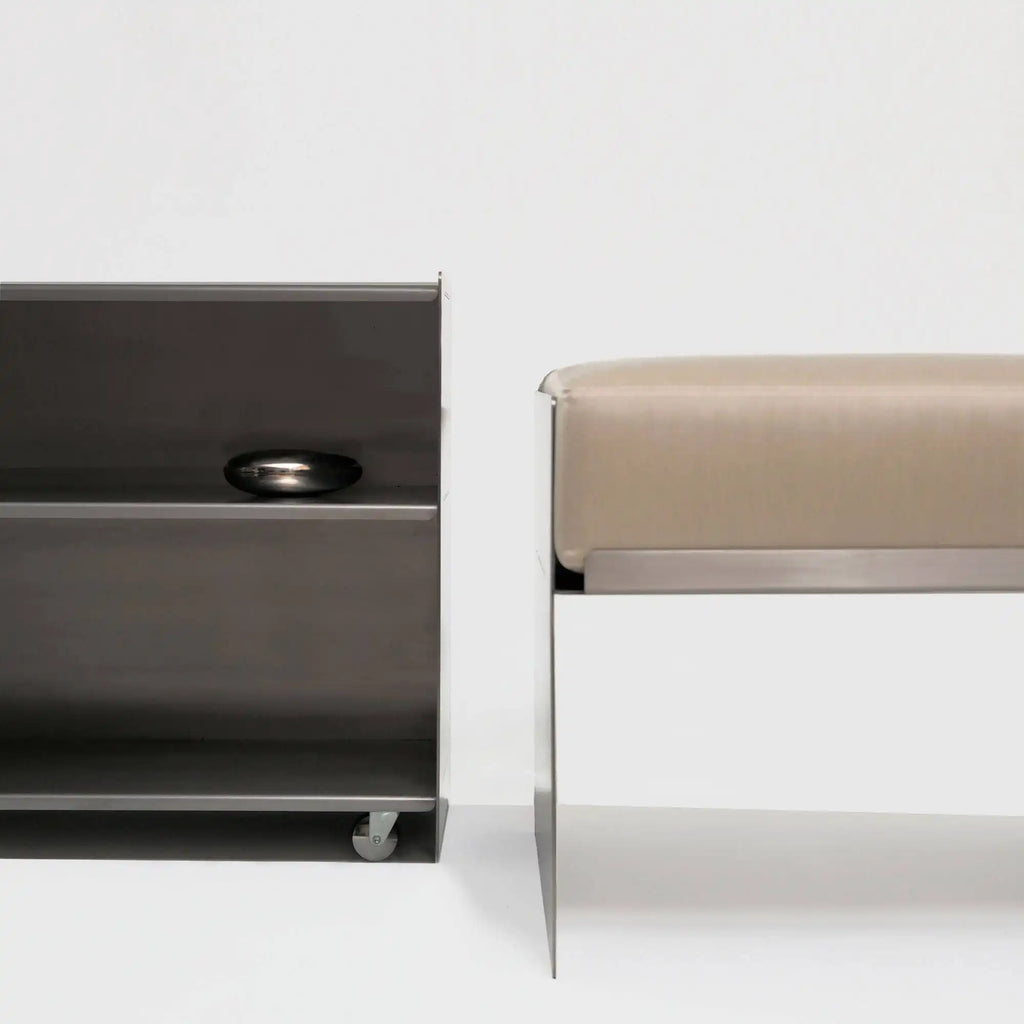 Around Works C.01 Lounge, a modern minimalist pouf featuring a plush light beige upholstered cushion resting on a sleek polished silver metal frame.