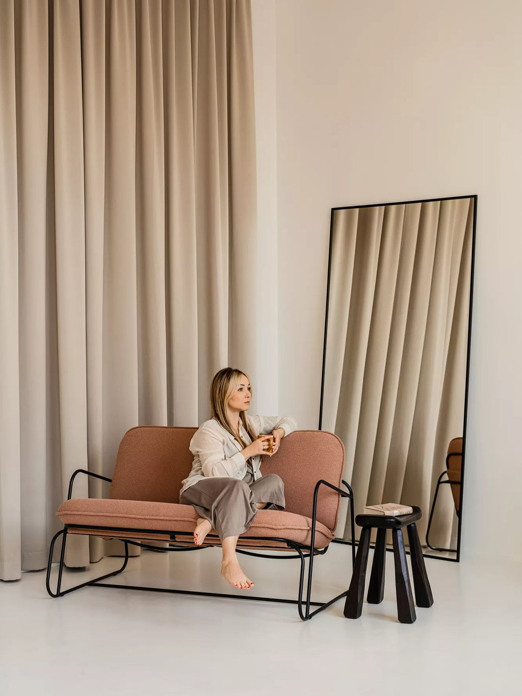 ARTU Tuttu Monteur Sofa, a modern minimalist 2-seater sofa featuring plush terracotta pink textured fabric upholstery with a gently curved backrest and deep seat cushions. It rests on a sleek matte black metal frame, offering a contemporary and organic modern design perfect for small living rooms, cozy reading nooks, or Scandinavian-inspired apartment spaces.