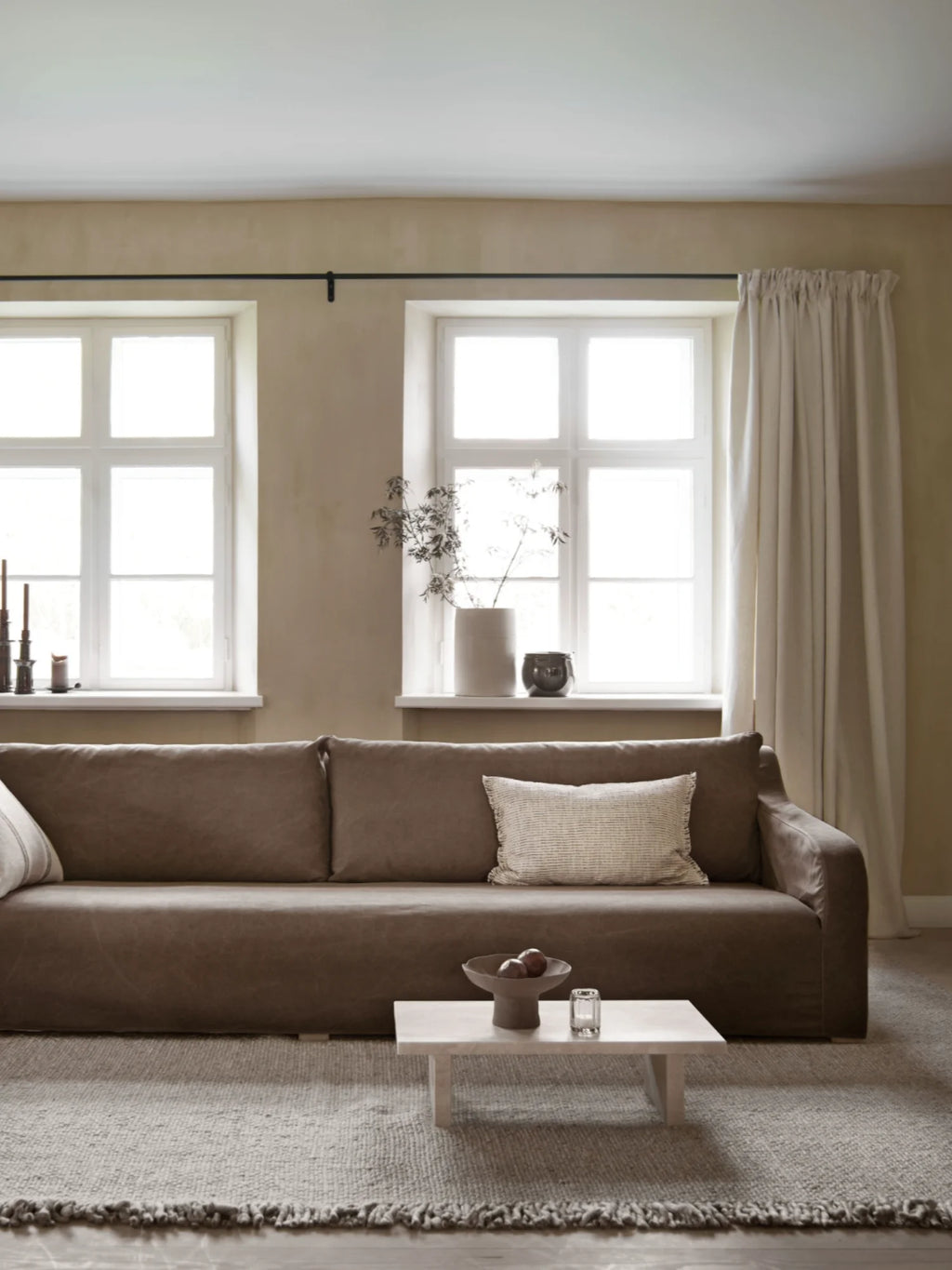 Tine K Sand Wool Rug, a natural hand-woven wool area rug in a warm sand-beige color, featuring a chunky textured weave and delicate fringed edges. This neutral floor covering is perfect for Scandinavian living rooms, organic modern bedrooms, or minimalist dining spaces seeking a cozy, textural element.