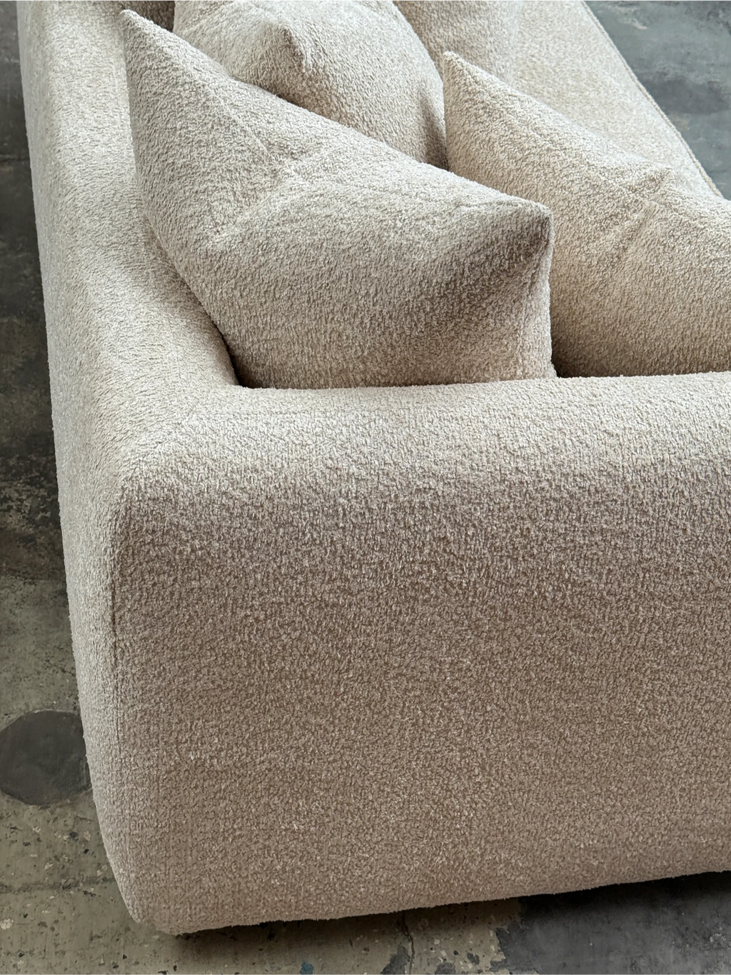 Tinted Objects Cornell Sofa, a modern minimalist sofa upholstered in a luxurious cream bouclé fabric with a highly textured, looped weave. It features deep, plush seating, soft rounded edges, and a low-profile, organic modern design. This cozy contemporary sofa is perfect for Scandinavian living rooms, Japandi-inspired spaces, or any elegant lounge area seeking comfort and style.
