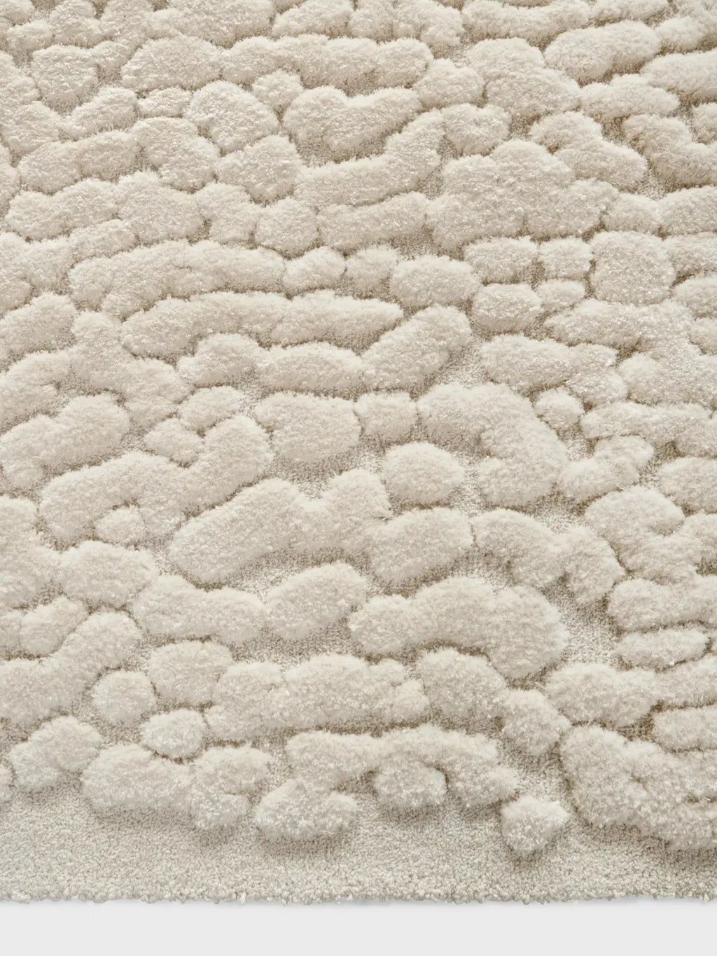 alp_ Borneo Rug, a luxurious cream-colored area rug with an incredibly plush, high-pile texture featuring raised, soft organic shapes that mimic natural formations. Crafted from a cozy blend of fibers in warm ivory and off-white tones, this contemporary rug adds inviting warmth. Ideal for organic modern living rooms, minimalist bedrooms, or cozy Scandinavian interiors.