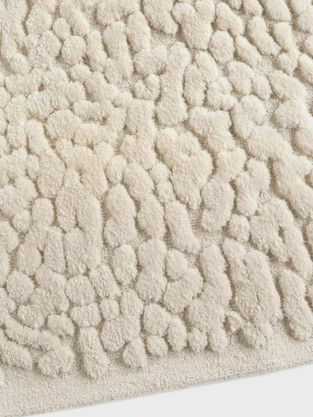 alp_ Borneo Rug, a cream-colored high-pile area rug featuring a plush, textured surface with organic, irregular raised patterns, crafted from a soft wool blend.
