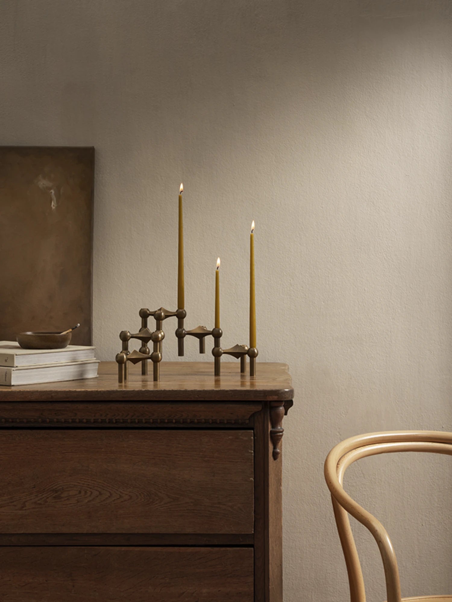 Stoff Nagel Taper Candles - Set of 6, a collection of long, slender candles in a warm mustard yellow hue, designed to perfectly complement the iconic modular Stoff Nagel candle holders. These elegant taper candles provide a soft, inviting glow, ideal for creating a cozy ambiance in modern minimalist, mid-century modern, or contemporary living spaces.
