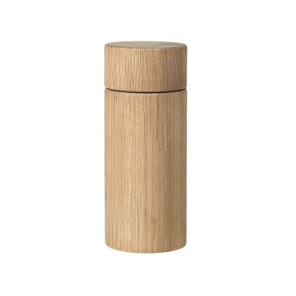 Broste Copenhagen Oak Grinder, a modern minimalist cylindrical spice grinder crafted from natural solid oak wood with a visible light wood grain texture. Its clean Scandinavian design features a smooth, light brown finish and a distinct top section for easy operation, making it a stylish and functional kitchen accessory. Perfect for contemporary kitchen counters, dining table decor, or organic modern culinary spaces.