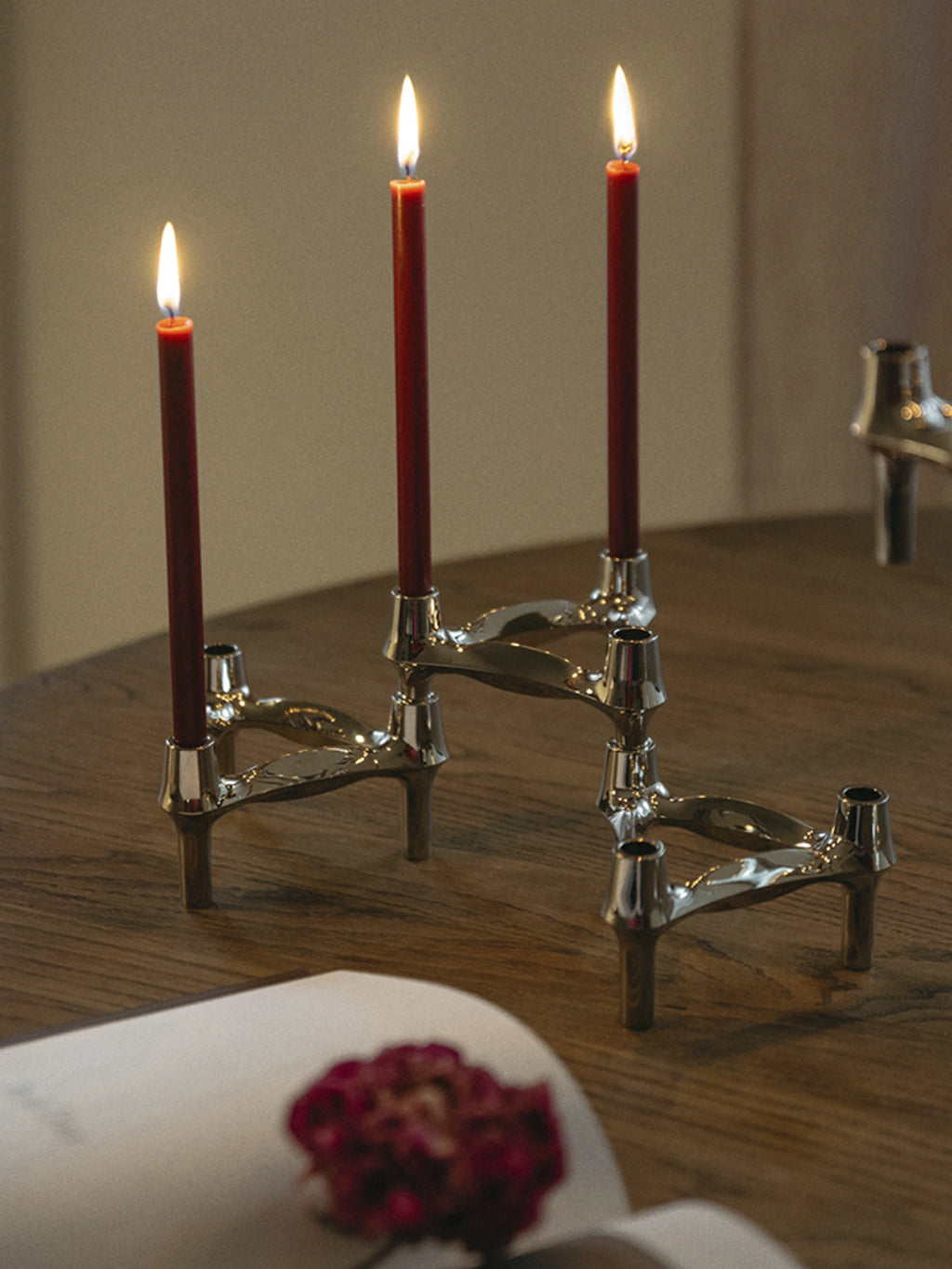 Handcrafted red candles in a set of 8, on top of a wooden dining table, perfect for home decor and ambiance. 

