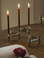 Handcrafted red candles in a set of 8, on top of a wooden dining table, perfect for home decor and ambiance. 
