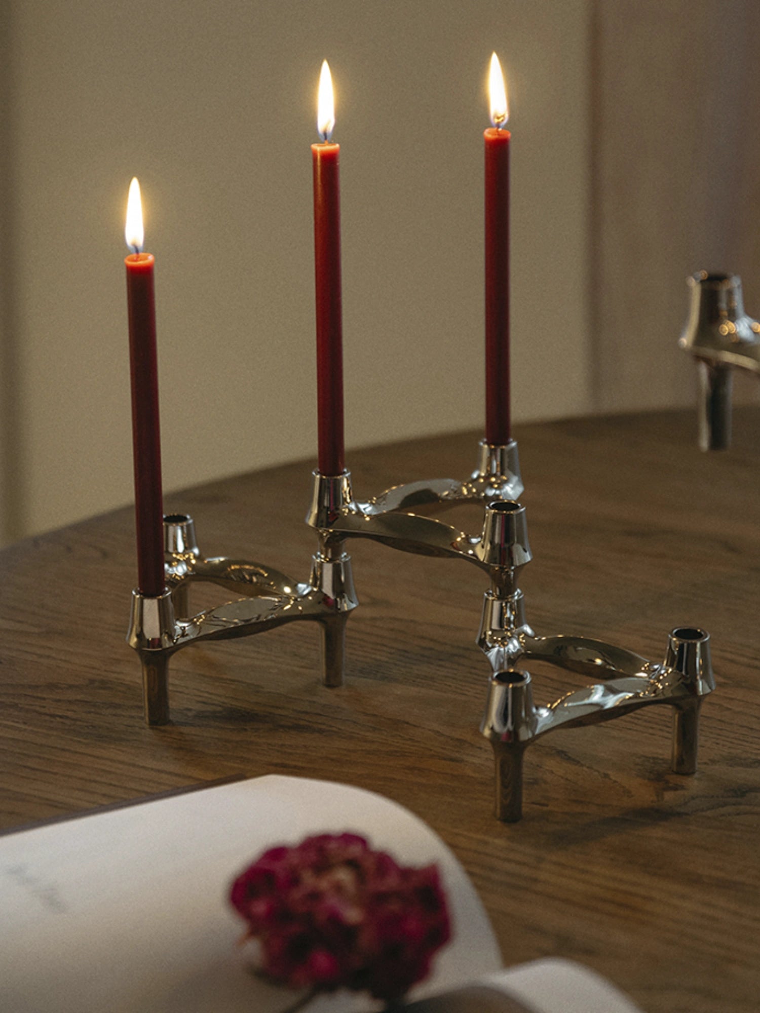 Handcrafted red candles in a set of 8, on top of a wooden dining table, perfect for home decor and ambiance. 
