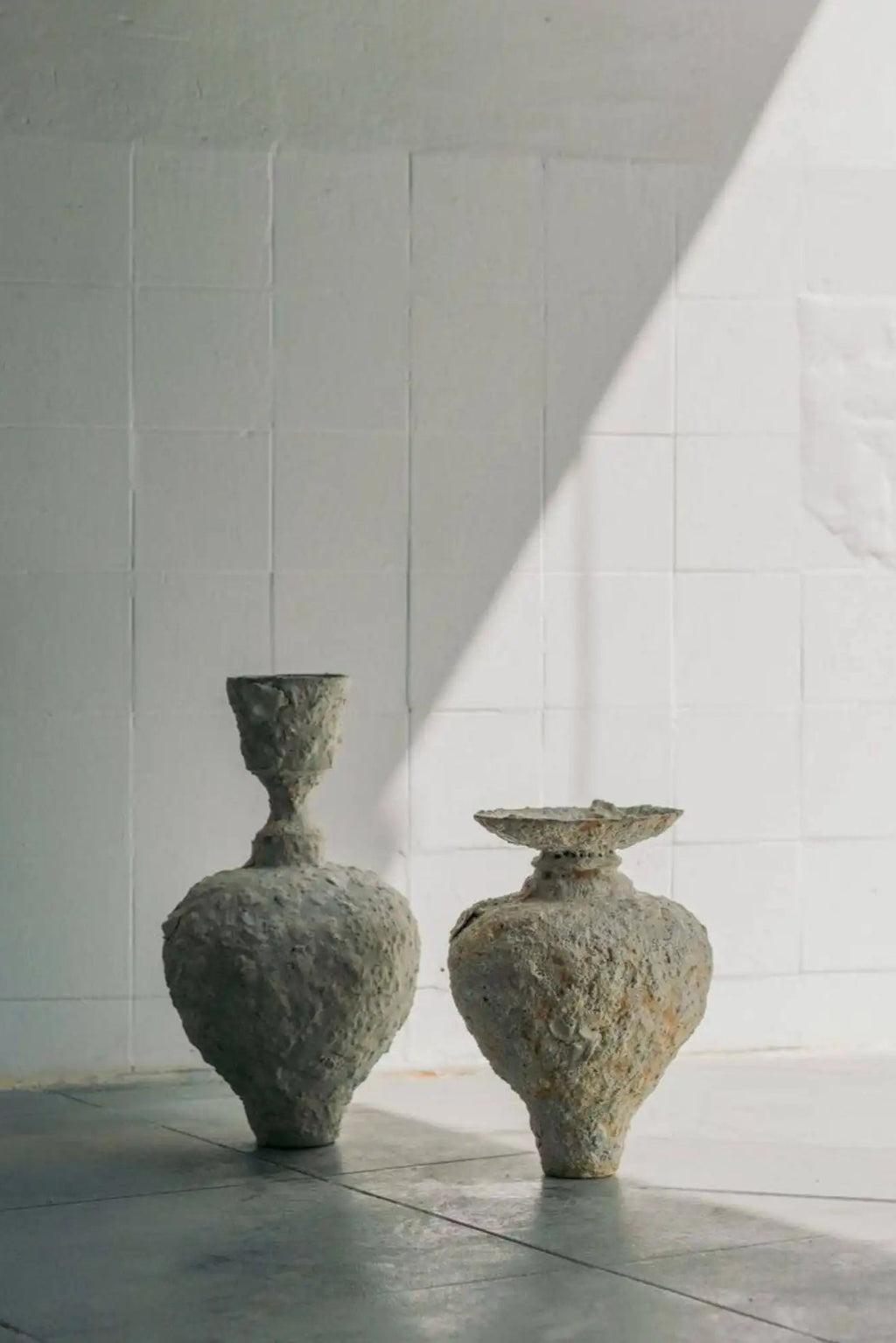 Canoa Lab Isolated n.21 Vase, a set of two handcrafted stoneware vases with a deeply textured, porous, and raw volcanic finish in earthy grey and natural stone tones.