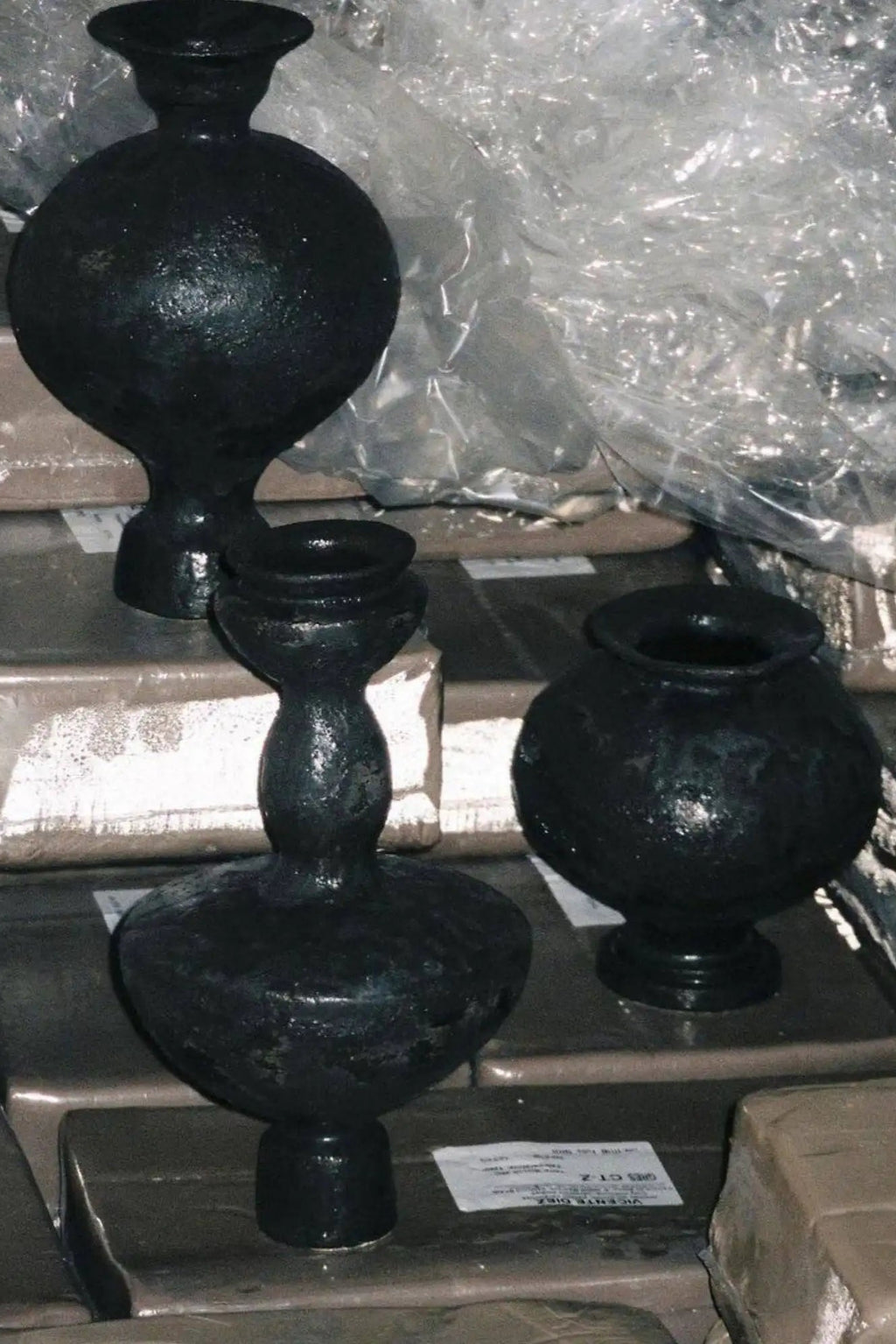 Canoa Lab Stamnos Vase collection, a set of three handcrafted matte black ceramic vases, each with a deeply textured, porous volcanic finish and robust stoneware construction.