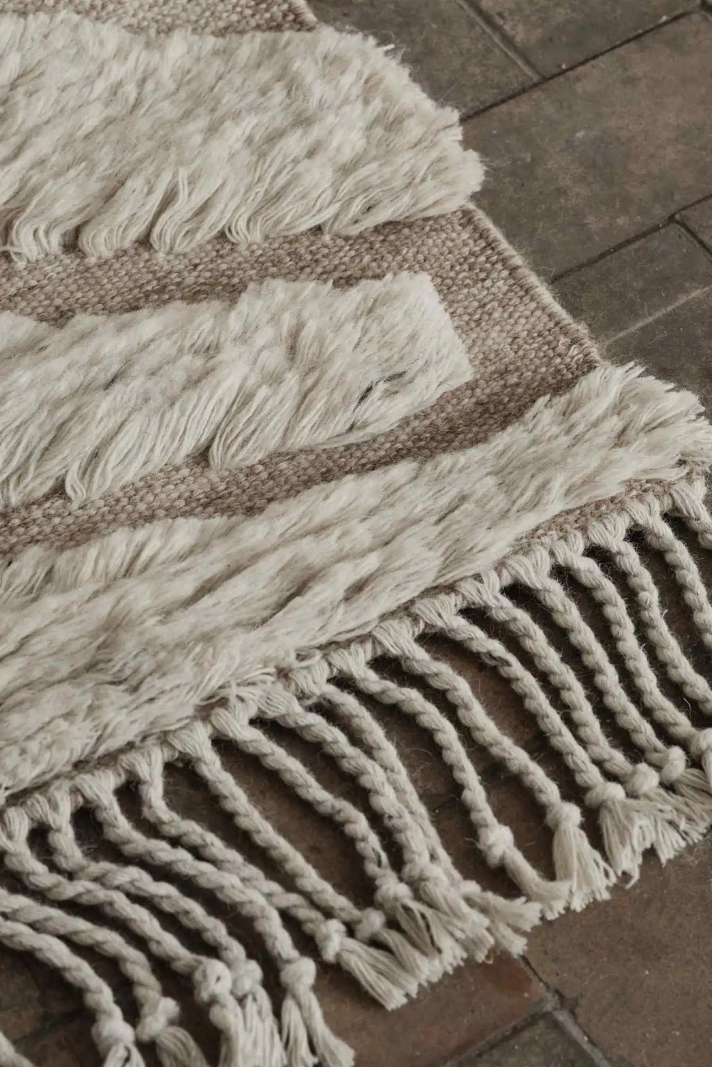 Cappelen Dimyr Colonnade No.01 Rug, a luxurious hand-knotted wool area rug featuring a high-pile shaggy texture in natural cream and a flat woven base in soft beige, finished with distinctive braided fringe tassels. This organic modern rug is perfect for adding warmth and texture to Scandinavian living rooms, boho bedrooms, or cozy minimalist spaces.
