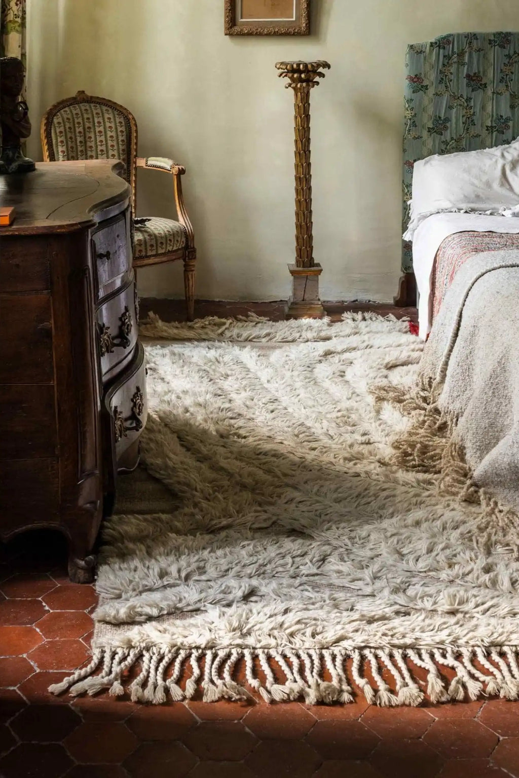 Cappelen Dimyr Colonnade No.01 Rug, a luxurious hand-knotted wool area rug in natural undyed cream and off-white tones, featuring a plush, shaggy long pile texture and distinctive braided fringe detailing. This organic modern rug is perfect for creating a cozy, rustic Mediterranean or Scandinavian atmosphere in bedrooms and living rooms.