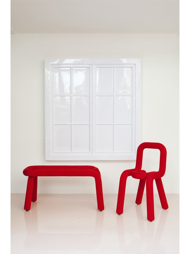Moustache Bold Chair, a vibrant red contemporary chair featuring a sculptural tubular metal frame wrapped in plush textile upholstery, forming a continuous, rounded, and playful silhouette. This bold design statement is perfect as a modern dining chair, a distinctive accent piece for living rooms, or a creative addition to a home office.