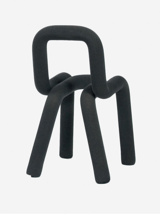 Moustache Bold Chair, a striking dark grey chair featuring a continuous tubular form with a padded metal structure covered in a soft, textured anthracite textile.