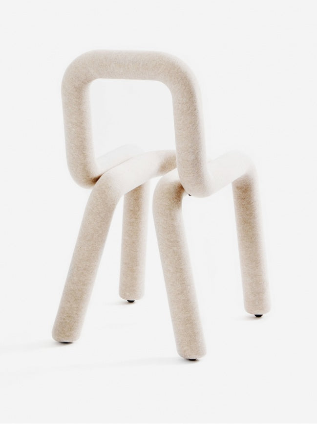 Moustache Bold Chair, a contemporary sculptural chair featuring a continuous tubular metal structure heavily padded and upholstered in a soft, textured natural cream felted wool fabric. Its minimalist, playful design forms a rounded seat, backrest, and four sturdy legs. Perfect as a unique designer accent chair for modern living rooms, avant-garde dining spaces, or stylish home offices.