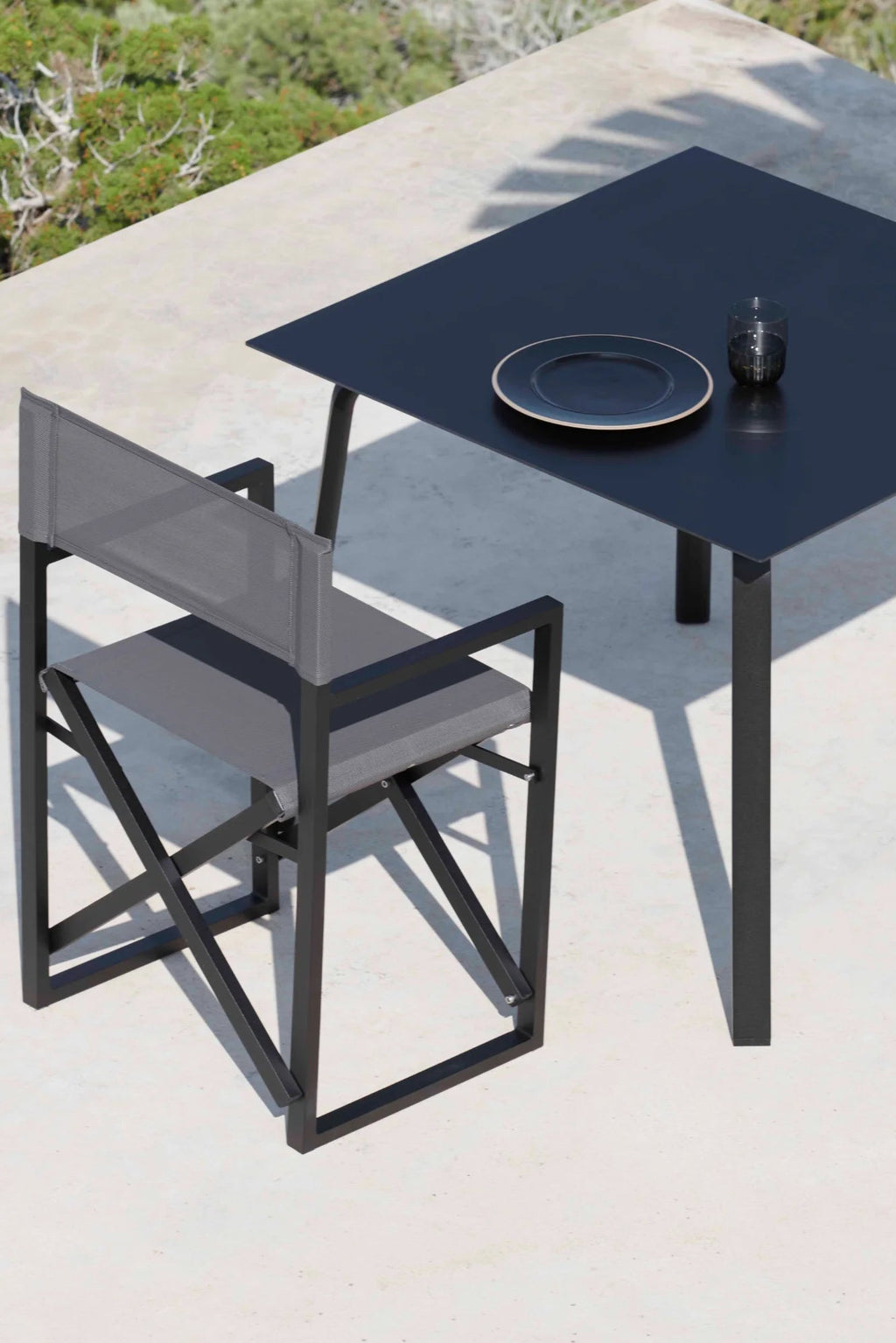 Gandia Blasco Clack! Outdoor Folding Chair, a modern minimalist design featuring a sleek matte black aluminum frame with a grey woven mesh fabric backrest and a matching grey textile seat. This contemporary outdoor dining chair boasts an innovative folding X-leg base for easy storage and a clean, architectural silhouette, perfect for stylish patio furniture, balcony seating, or poolside entertaining.