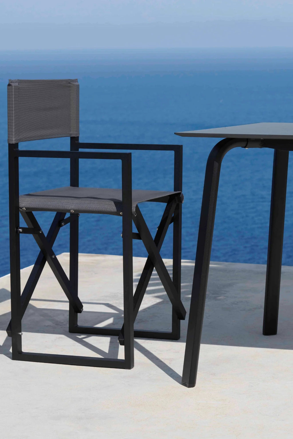 Gandia Blasco Clack! Outdoor Folding Chair, a modern minimalist folding chair featuring a sleek matte black aluminum frame with clean geometric lines and a dark grey textilene fabric seat and backrest. This contemporary outdoor chair is perfect for stylish outdoor dining, compact balcony furniture, or durable patio seating.