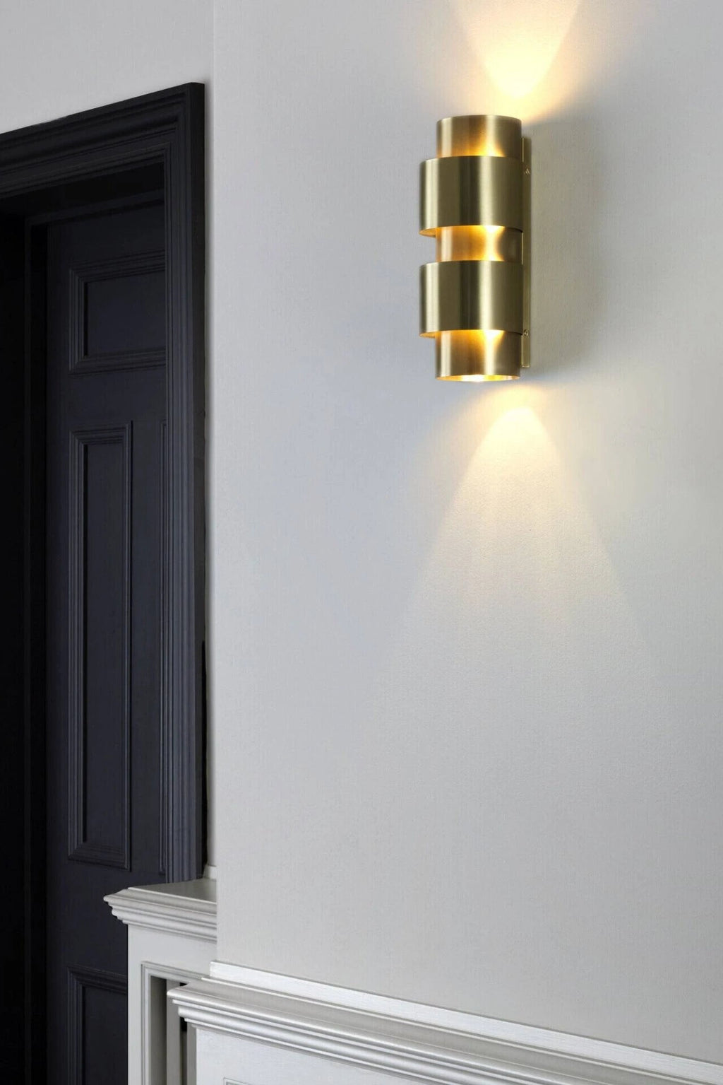 CTO Lighting Ring Wall Lamp - Short, a luxurious modern wall lamp crafted from brushed brass with a distinctive stacked cylindrical ring design, providing both uplight and downlight illumination. This contemporary gold wall sconce adds architectural elegance and warm ambient lighting. Perfect for sophisticated living rooms, hallways, or entryway lighting in minimalist and luxury interiors.