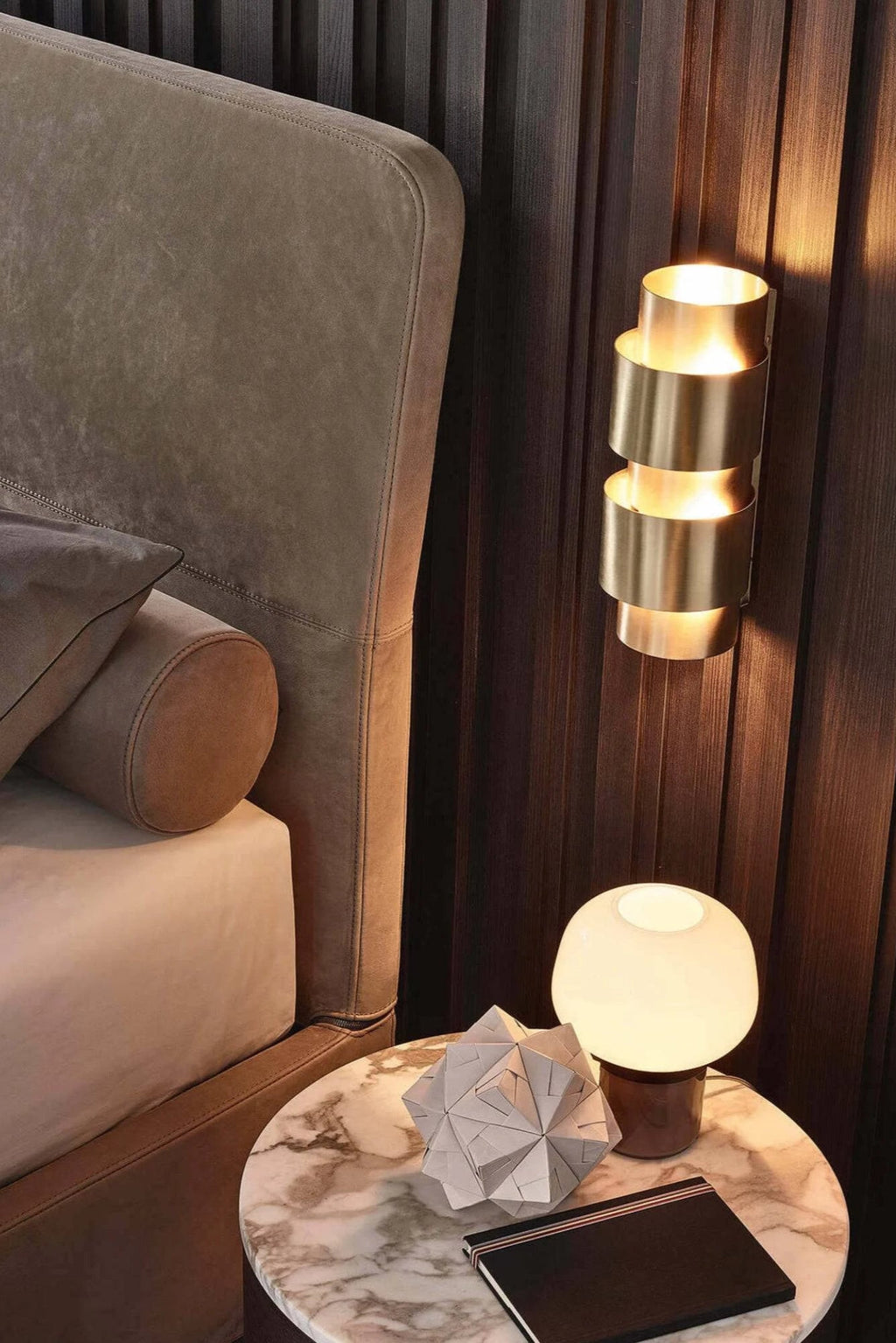 CTO Lighting Ring Wall Lamp - Short, a luxurious modern wall sconce crafted from brushed brass with a stacked cylindrical design that casts warm ambient light both upwards and downwards. This elegant brass wall light is perfect for adding contemporary style and a soft glow to a sophisticated bedroom, living room, or entryway.