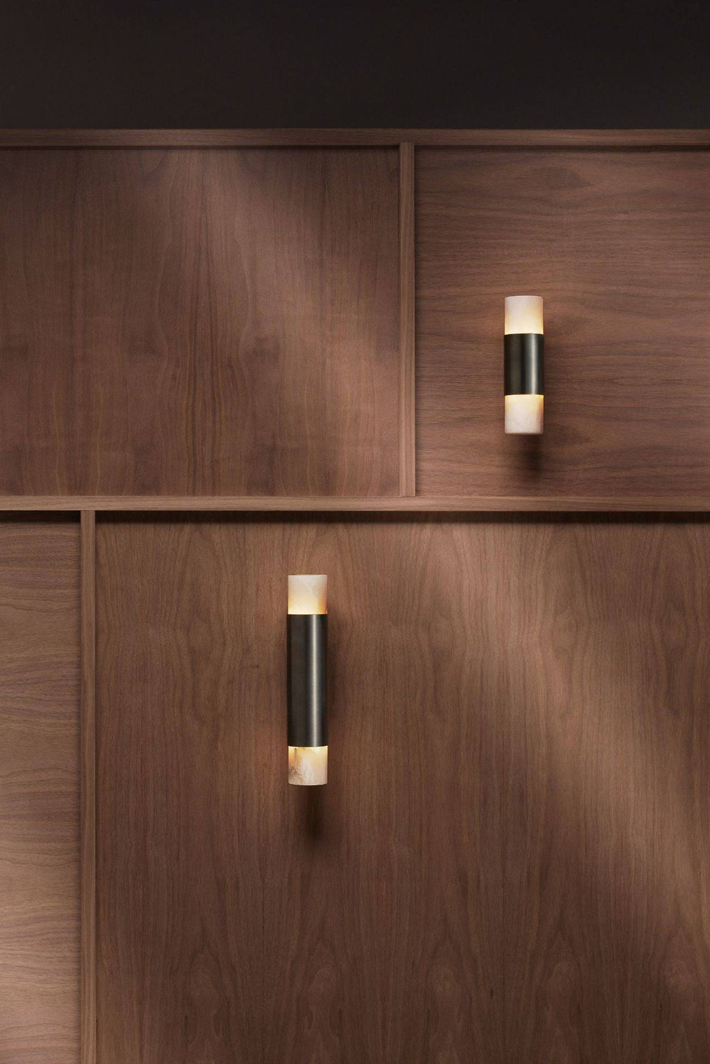 CTO Lighting Roma Wall Lamp, a luxurious modern wall light featuring a sleek cylindrical design with a dark brushed bronze central band and translucent creamy white alabaster shades on the top and bottom, creating an elegant up/down lighting effect. This contemporary alabaster wall sconce is perfect for adding sophisticated ambient light to luxury living rooms, hallways, or modern bedrooms.