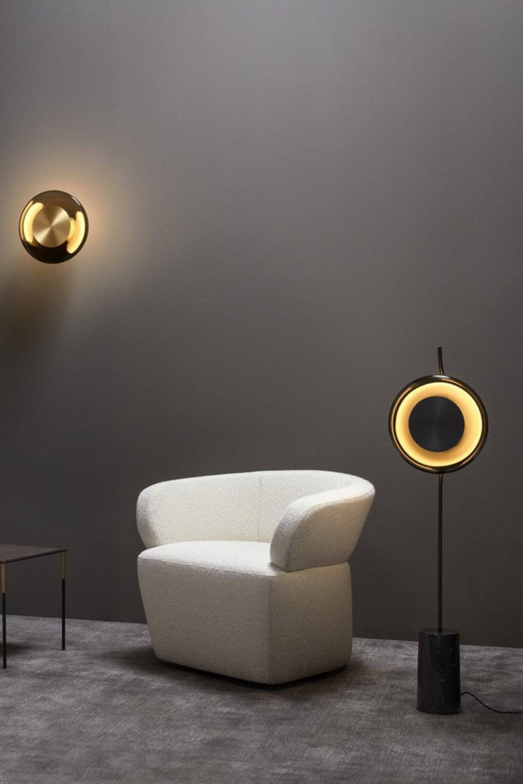 CTO Lighting Pendulum Floor Lamp, a striking modern minimalist floor lamp featuring a matte black metal frame with a circular light head that emits a warm, diffused glow from a brushed brass inner ring. It stands on a slender stem with a heavy, cylindrical black marble base, providing both stability and a touch of luxury. This contemporary standing lamp is perfect for adding sophisticated accent lighting to living rooms, bedrooms, or upscale home offices.