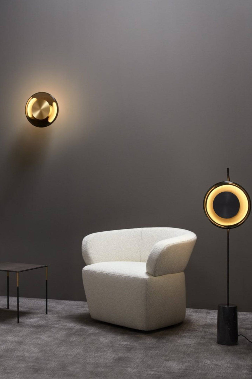 CTO Lighting Pendulum Wall Lamp, a luxurious modern minimalist wall light featuring a central brushed brass disc surrounded by a dark bronze or black metal outer ring, emitting a warm, ambient glow. This contemporary circular sconce provides sophisticated decorative lighting for living rooms, hallways, or upscale bedrooms.