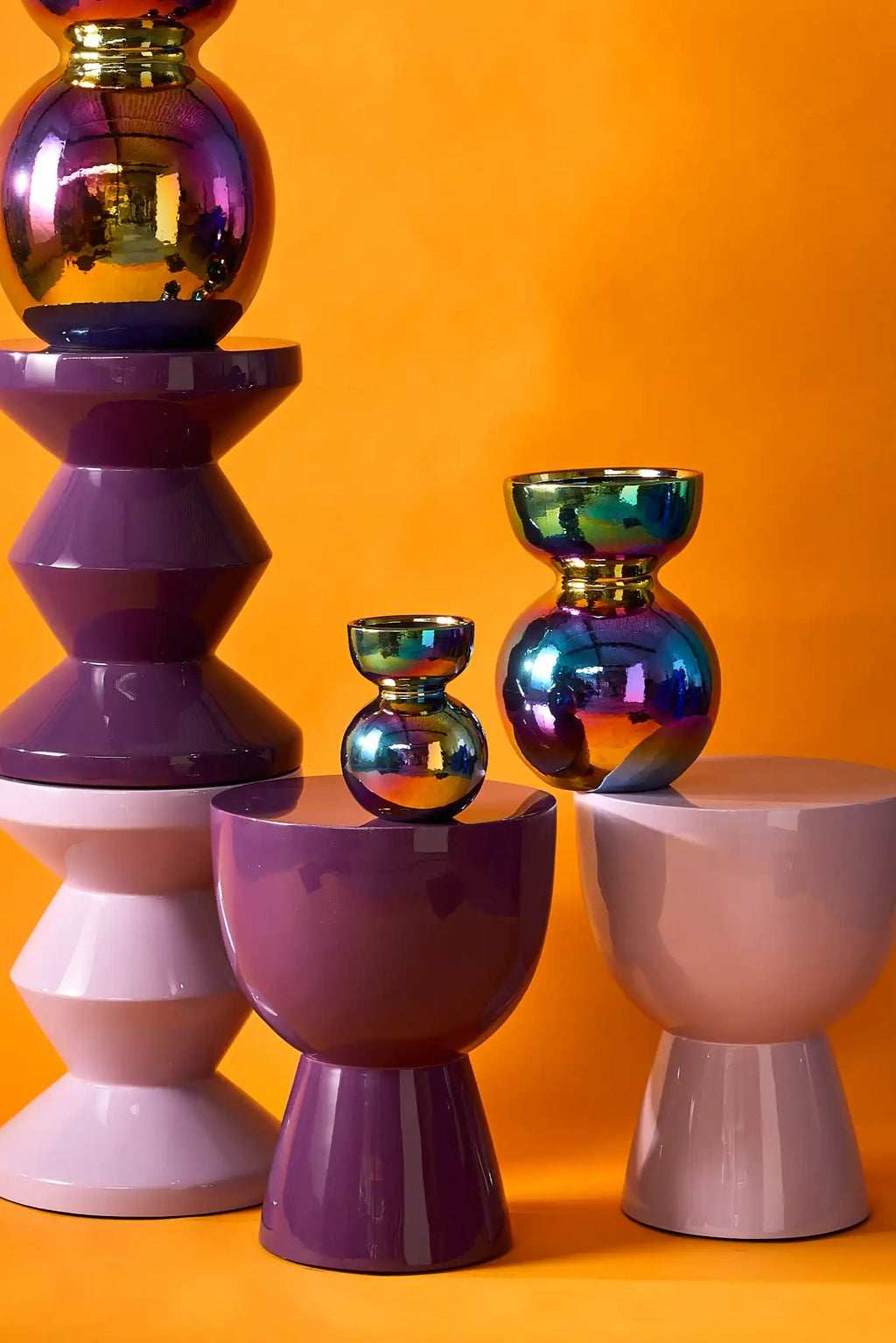 POLSPOTTEN Tip Tap Stool, a vibrant collection of modern sculptural stools with a glossy lacquered finish in bold deep purple, light lavender, and pale grey-blush tones.