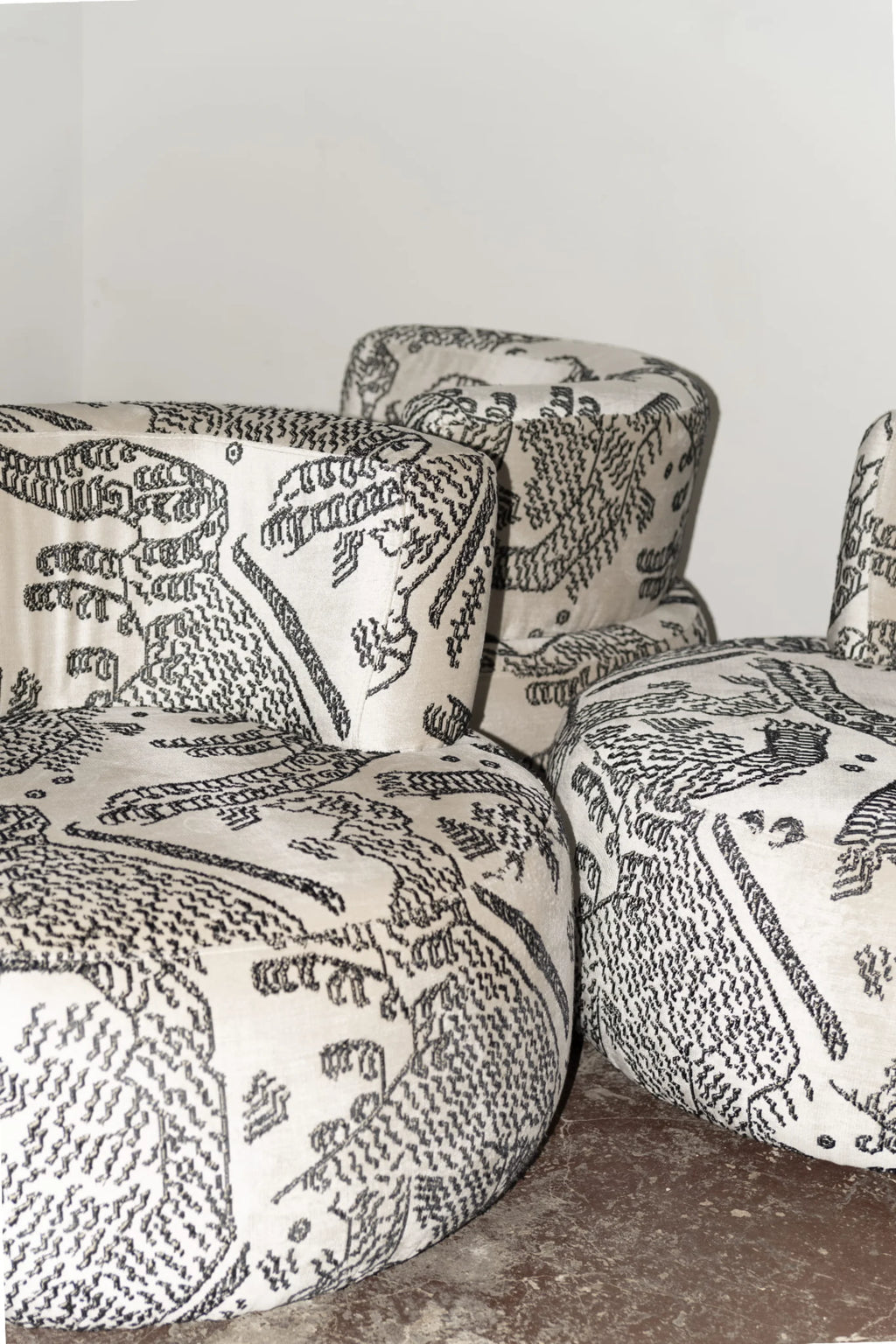 NG DESIGN Object 051 Lounge Chair; close-up of three cream velvet upholstered chairs with black embroidered abstract patterns, showcasing luxury artisan craftsmanship. Ideal for stylish interiors.