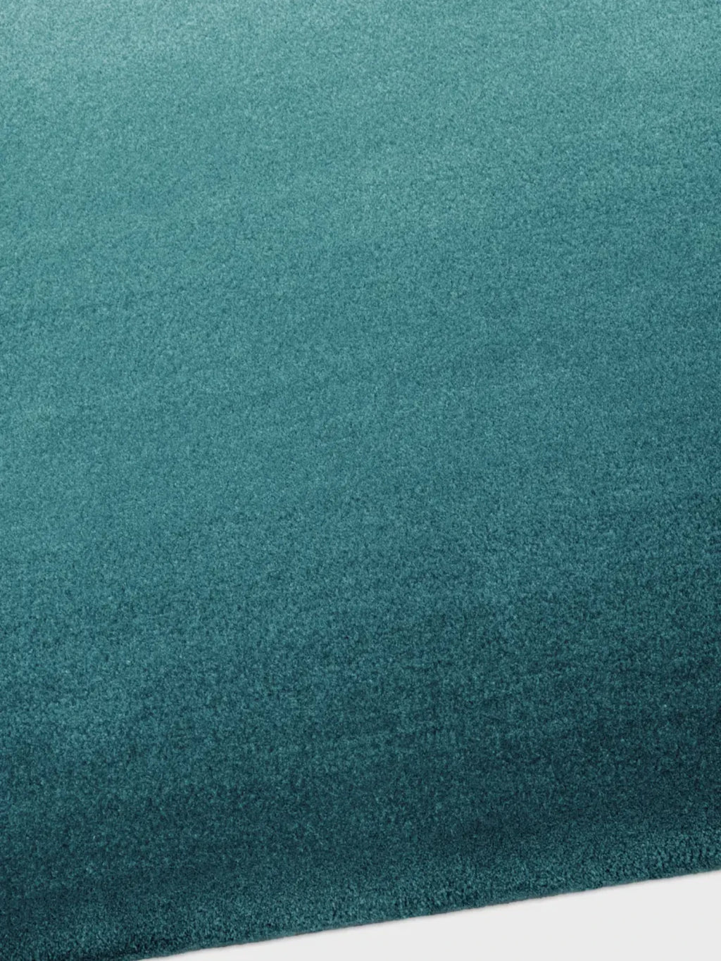 alp_ Degradé Double Rug, a luxurious contemporary area rug featuring a striking ombré teal color gradient that transitions from a lighter aqua to a deep, rich turquoise.