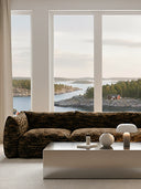 Modern living room with a large Rèverie sofa in Jacquard fabric and a scenic scandinavian view of water and trees.