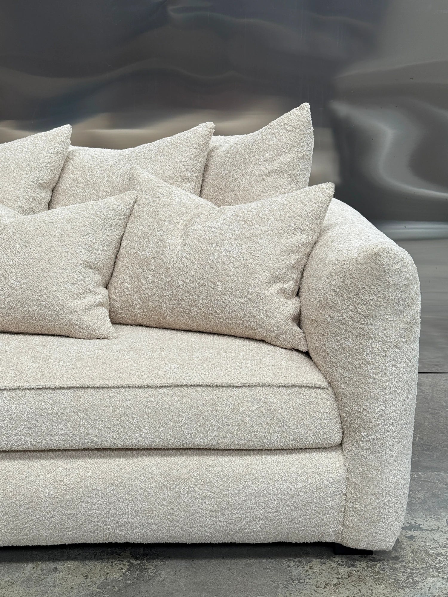 Tinted Objects Cornell Sofa, a plush cream bouclé sofa featuring soft, textured fabric upholstery with generous deep seating and gently rounded arms, accompanied by matching throw pillows. This contemporary organic modern couch is perfect for creating a cozy minimalist living room or a Scandinavian-inspired space.