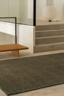 A luxurious, handwoven surface rug with a modern geometric pattern