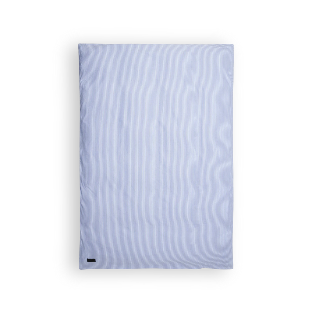 Magniberg Wall Street Duvet Cover - Stripe Light Blue Oxford, a classic light blue and white striped duvet cover crafted from soft oxford cotton fabric, featuring fine vertical stripes and a crisp, clean aesthetic. This timeless striped bedding is perfect for a modern minimalist bedroom or a serene Scandinavian sleep space.