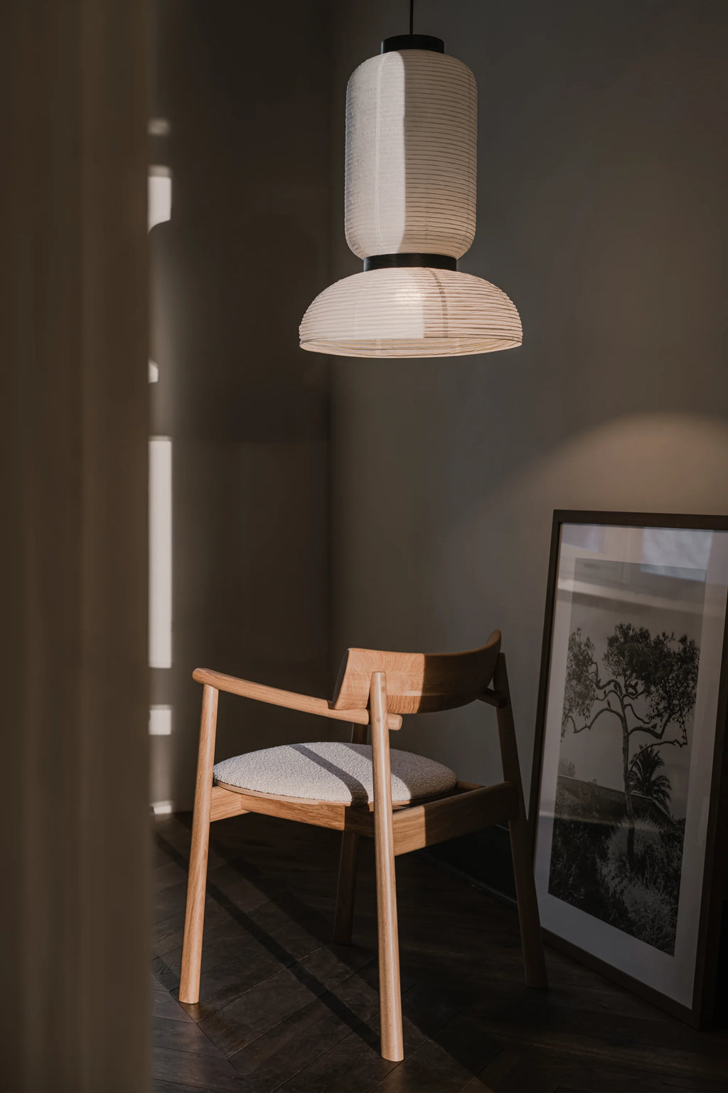 TAMO Elipsa Chair, a premium light oak wood dining chair with a curved backrest and a light beige textured fabric seat, in a stylish living room setting. Ideal for sophisticated interiors.