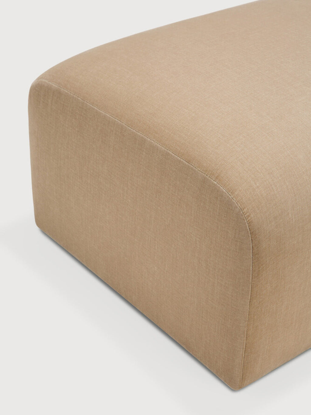 Ethnicraft Bulky Modular Sofa 90-degree round corner module, detailed close-up. This image highlights the exquisite craftsmanship and the soft, textured beige fabric upholstery, showcasing the smooth, rounded edges and premium material quality. Displayed on a light grey background.